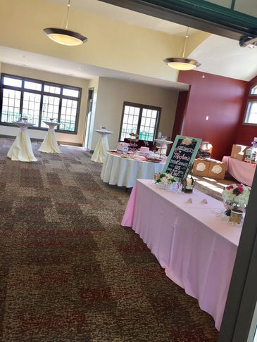 Empty event room with pink and white tables set for a reception.