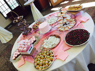 Pink baby shower dessert table with cake pops and chocolate strawberries.