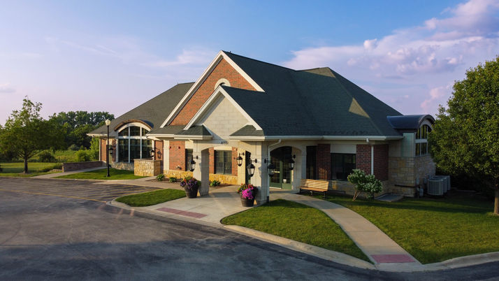 Professional modern building entrance, brick facade, landscaped grounds, and the building is called the Event Centre.