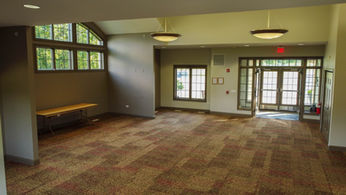 Spacious, modern empty lobby with patterned carpet and large windows.